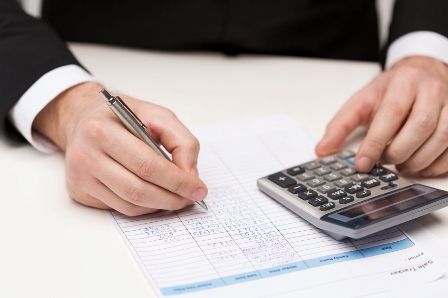 close up of businessman with papers and calculator